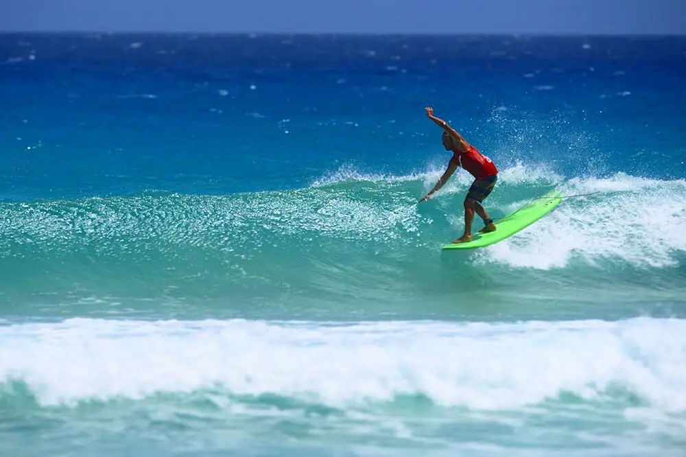 Surfer is riding a wave on the nose of his foami