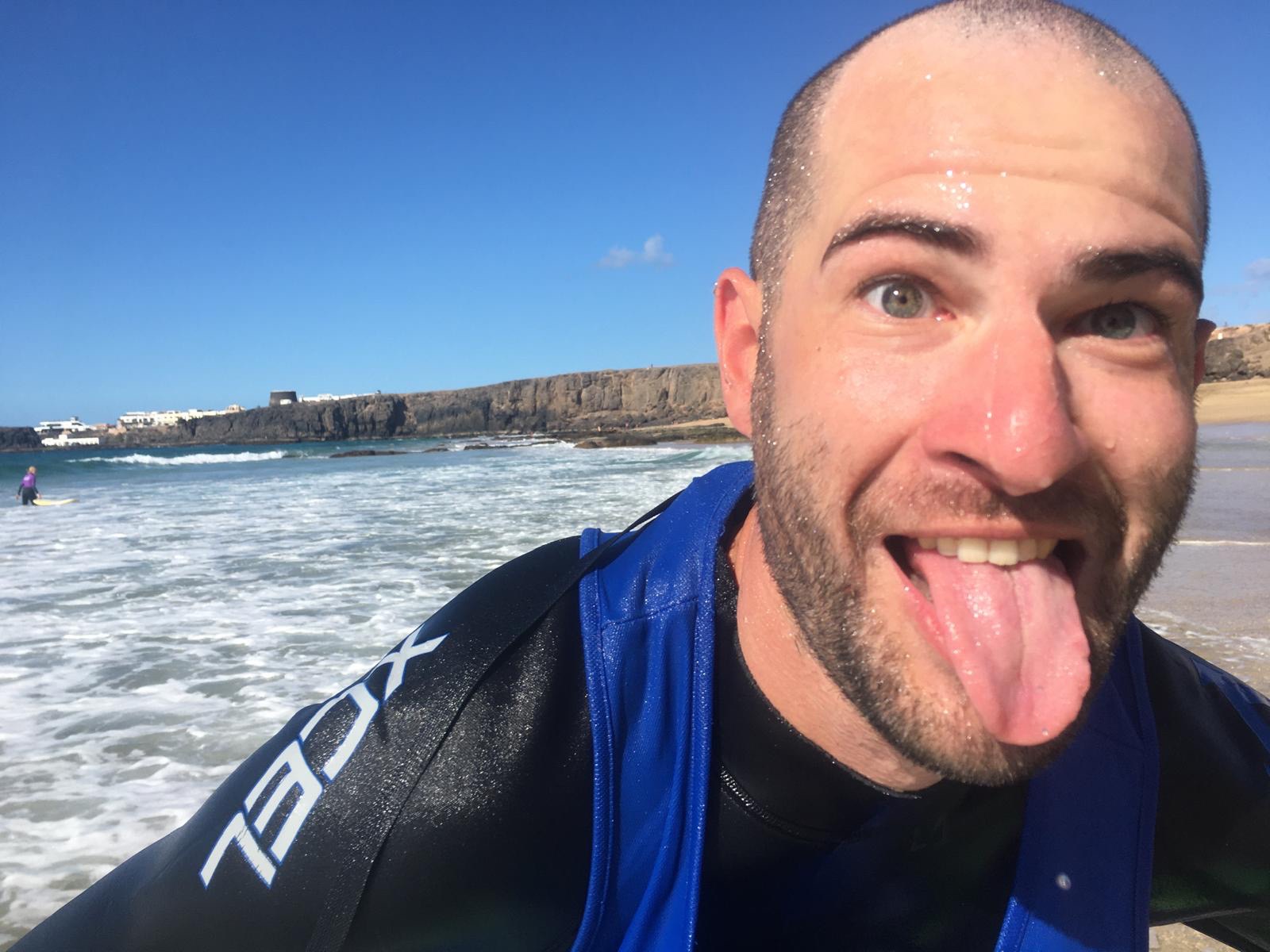 Glücklicher Surfschüler nach dem Anfänger-Surfkurs auf Fuerteventura