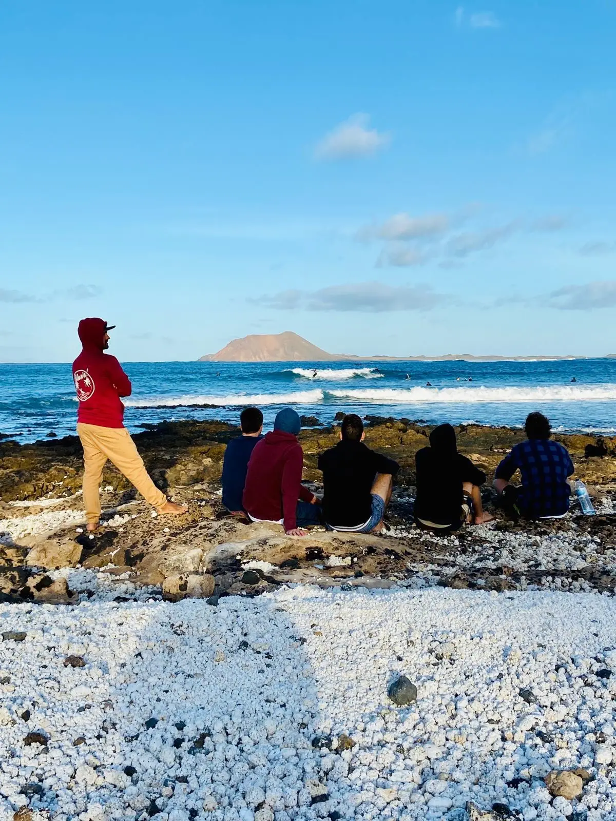 Surfkurs-Gruppe beobachtet Wellen und Surfbedingungen auf Fuerteventura